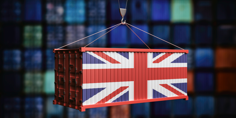 Shipping container painted with the UK flag being lifted by a crane, symbolising UK trade deals.