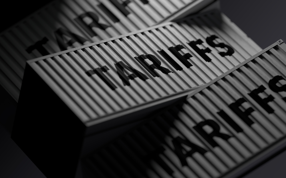 Shipping containers with the word "tariffs" painted on them.