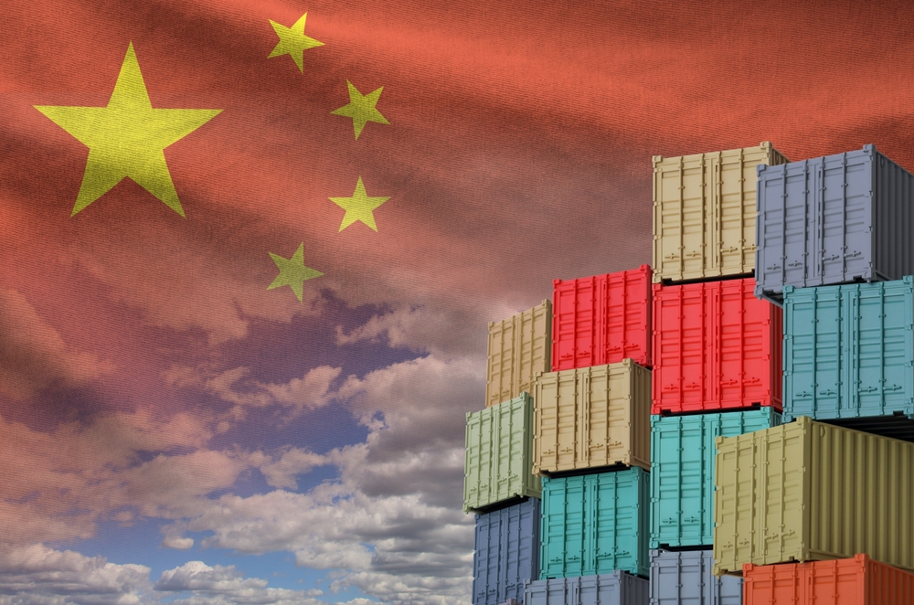 Image of the China flag and a big stack of shipping cargo containers.