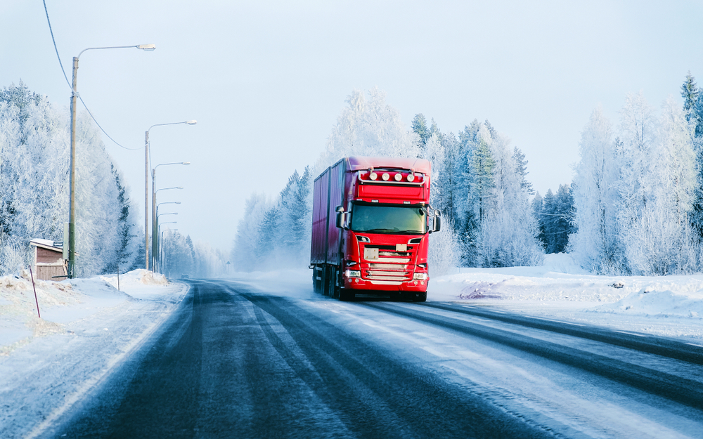 Image of a lorry on a winter road with snow, reflecting freight shipping during Christmas.